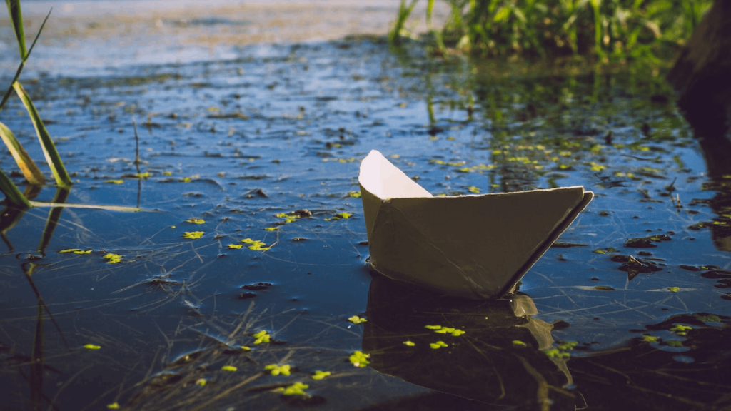 photo d'un bateau en papier flottant sur l'eau